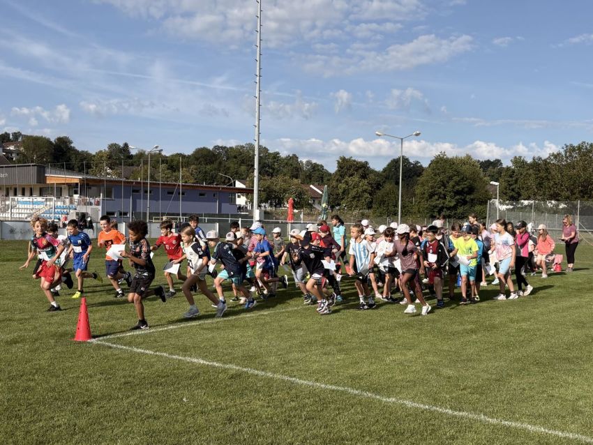 Viele Schüler laufen auf einem Sportplatz