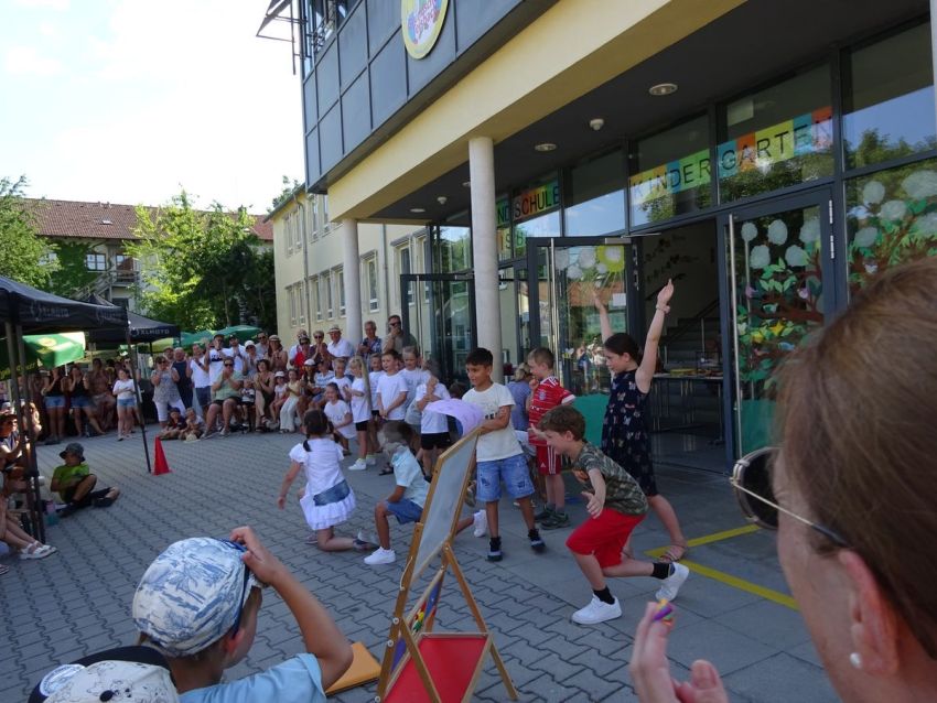 Kinder führen einen Tanz auf dem Schulhof auf