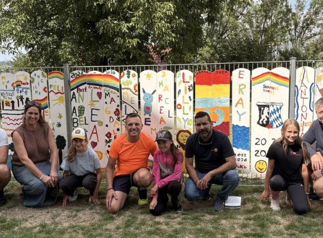 Gruppenbild vor bunten Zaunlatten