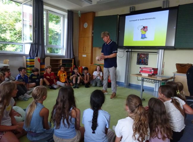 Kinder sitzen im Kreis auf dem Boden