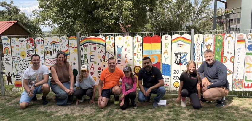 Gruppenbild vor bunten Zaunlatten