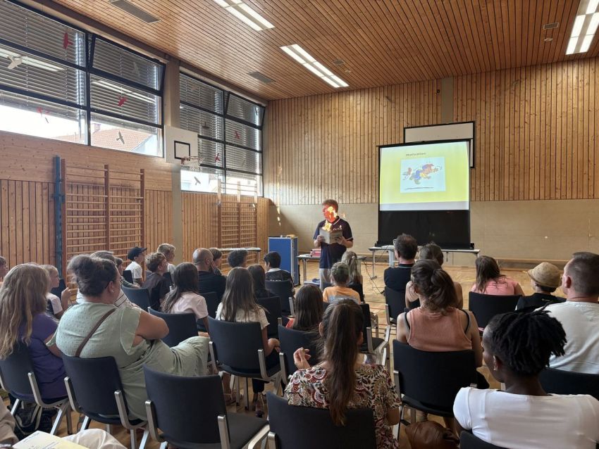 Eltern lauschen einer Präsentation in der Turnhalle
